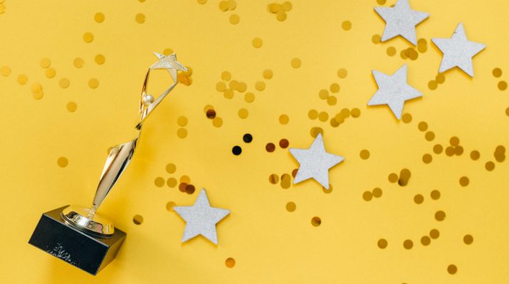 golden statuette and stars on yellow background