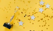 golden statuette and stars on yellow background